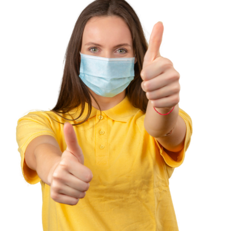 young-woman-yellow-polo-shirt-medical-protective-mask-showing-thumb-up-sign-looking-camera-with-positive-expression-orange-background-2000x1125-1-2000x1125